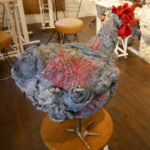 A grey and red chicken footstool