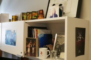 A shelf in Devon's office, lined with pictures of his past performances.