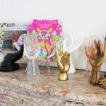 Tula Pink's mantle features a collection of hand statues that hold up two of her books.