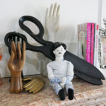 The mantle in Tula Pink's office features a collection of hand statuary, curios, and books.