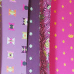 Paper printouts of Tula Pink's fabric line.