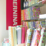 Tula Pink's All Stars fabric shares a corner with a Bernina sewing machine sign.