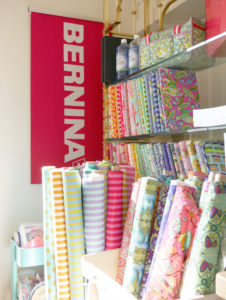 Tula Pink's All Stars fabric shares a corner with a Bernina sewing machine sign.