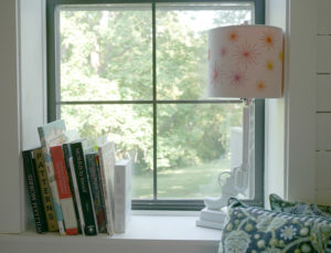 A cozy nook in Tula Pink's studio features inspirational books on William Morris