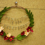 A floral wreath proclaims "feminism is for everybody", made by Grace D. Chin.