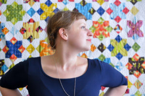 Lizzy House in front of a quilt that features her fabrics. Photo by Lizzy House.