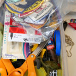 A pile of badges sit in a mismatched box in Luke's studio.